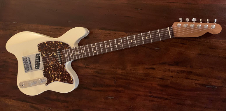 This picture of the ergonomic guitar shows the headstock and roasted maple neck