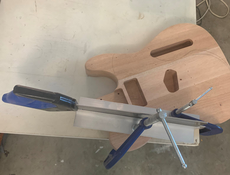 Clamps and guides for making cuts in the body of the guitar